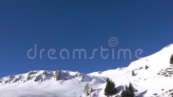 空中慢镜头飞越雪山山脊山谷蓝天视频的预览图