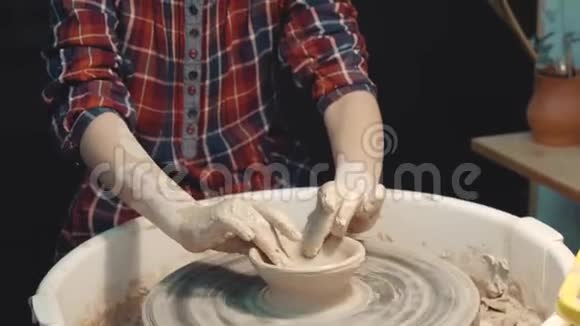一个严肃的小女孩集中精力在制作陶轮上的陶器视频的预览图