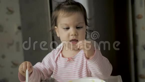 可爱的小母猪坐在喂食椅上在厨房里吃健康的食物视频的预览图