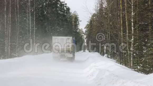 一辆载着矿石的卡车沿着一条狭窄的冬季森林道路行驶视频的预览图
