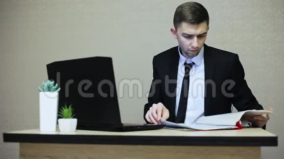 年轻的商人在办公室工作在笔记本电脑上打字视频的预览图