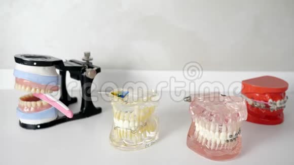 美丽的下巴模型和牙套铺设在白色桌子上视频的预览图