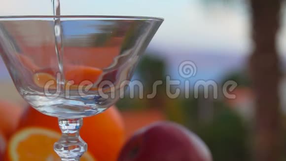 在柑橘类水果的背景下马丁尼被倒入玻璃杯中视频的预览图