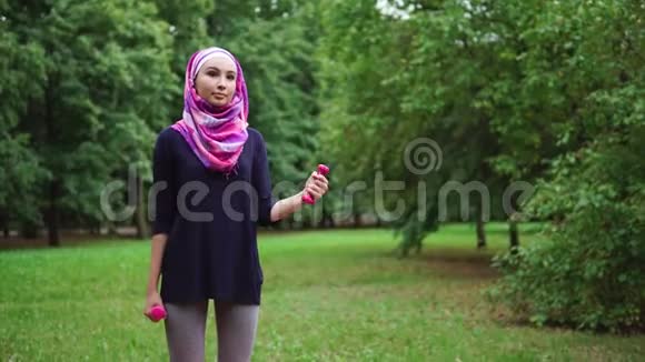 穆斯林女孩在户外用哑铃锻炼视频的预览图