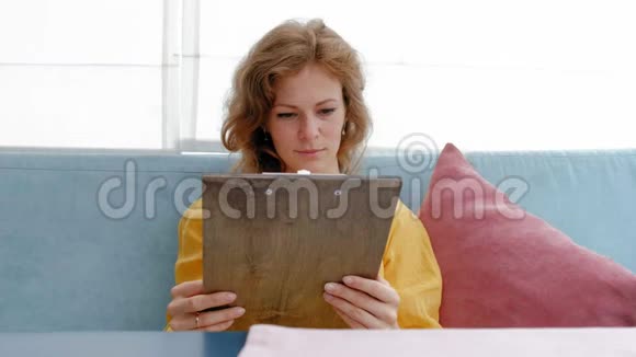 女人在餐厅看菜单翻页选盘子参加午餐约会视频的预览图