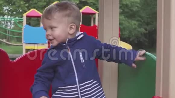 这个男孩在公园或幼儿园的操场上玩耍这孩子嬉闹很有趣视频的预览图