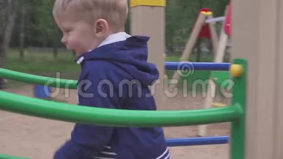 这个男孩在公园或幼儿园的操场上玩耍这孩子嬉闹很有趣视频的预览图