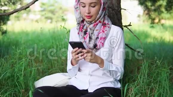 年轻和现代穆斯林妇女通过手机与朋友交流视频的预览图