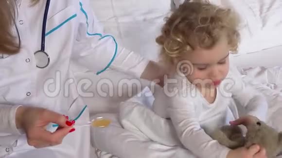 女医生用勺子和泰迪熊一起给孩子治病视频的预览图