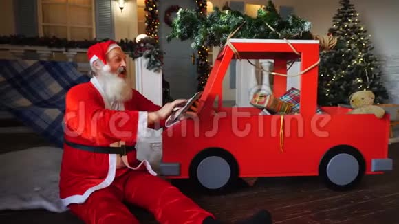 快乐的圣诞老人享受着现代的小玩意视频的预览图