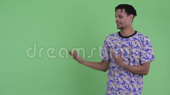 快乐的年轻英俊的非洲男人一边说话一边展示视频的预览图