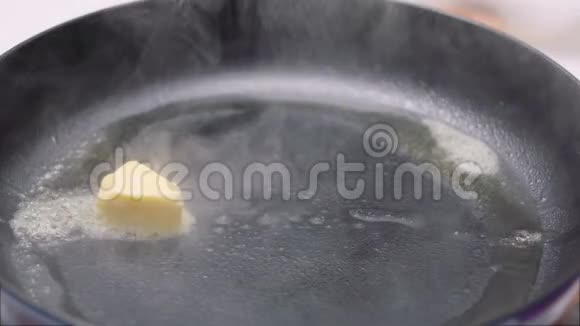 在不粘锅中缓慢移动融化黄油的方块铁板褐变烹饪准备50FPS视频的预览图