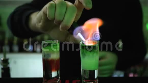 手臂较轻的人在酒吧柜台上用薄玻璃装饰着彩色层的鸡尾酒视频的预览图