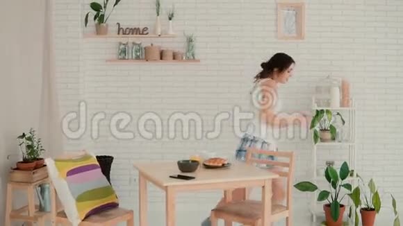 快乐而新鲜的女人在早上玩得很开心穿睡衣的女孩在厨房跳舞慢动作视频的预览图