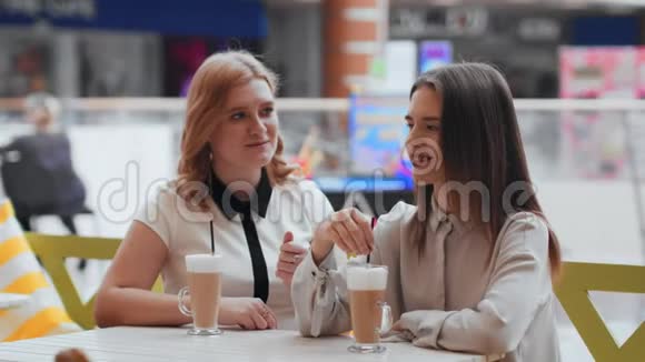 年轻女性喝咖啡在咖啡馆交流视频的预览图