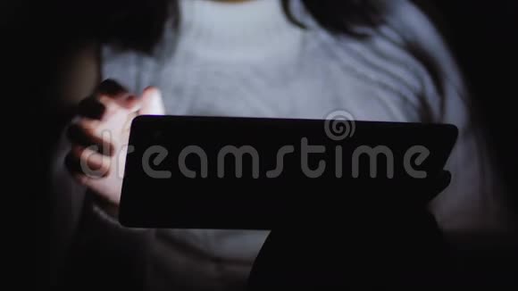 一个穿白色夹克的女人坐在黑暗中手里拿着一块药片视频的预览图