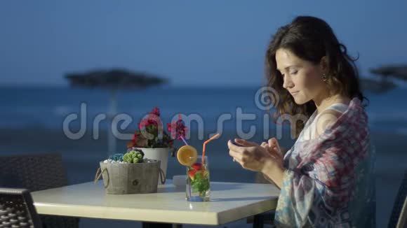 快乐的美女上网聊天在海边度假视频的预览图