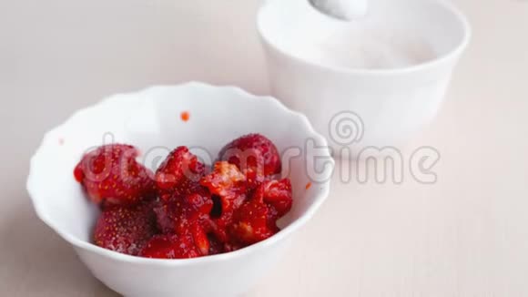 女人用叉子揉草莓把它和糖混在一起做果酱特写的手视频的预览图