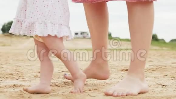 小女孩和她妈妈沿着沙滩散步视频的预览图