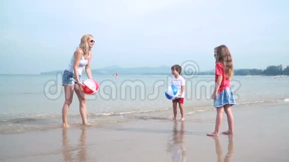 泰国美丽的沙滩上孩子们和妈妈玩着五颜六色的水球视频的预览图