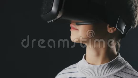 特写男孩10岁使用虚拟现实头盔儿童使用VR360的经验视频的预览图