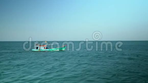这艘传统的小船在越南海上融化小渔船漂浮在绿松石的水面上视频的预览图