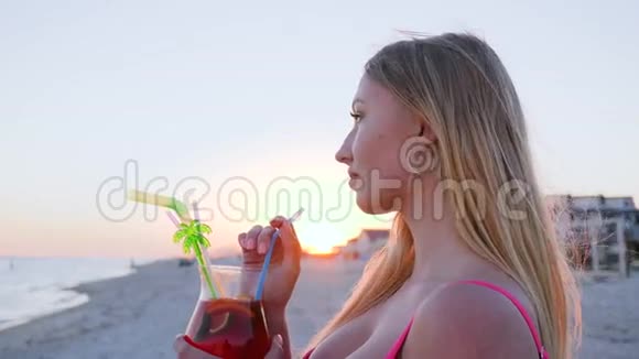肖像女性看着大海喝着彩色鸡尾酒风视频的预览图