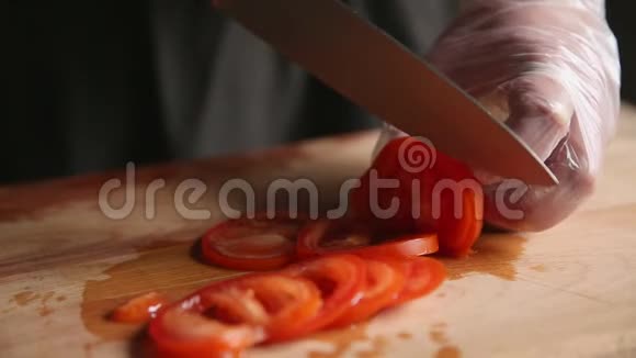 雄手特写将刀和熟番茄切片放在砧板上视频的预览图