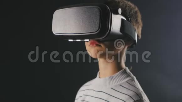 特写男孩10岁使用虚拟现实头盔儿童使用VR360的经验视频的预览图