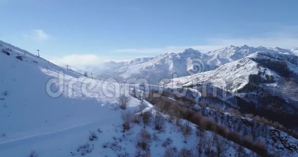 冬季白雪山山顶侧面空中露出滑雪者滑雪椅升降机森林树林雪山视频的预览图