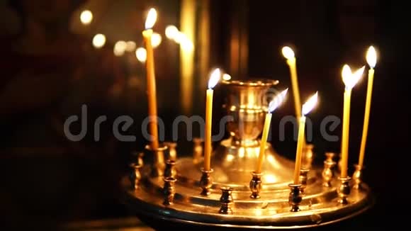 在基督教会的圣面前人们纠正烛台上燃烧的蜡烛视频的预览图