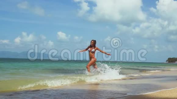 阳光明媚的夏日穿比基尼的年轻漂亮女人跑进大海慢动作1920x1080视频的预览图