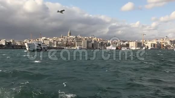 拍摄的加拉塔塔在前景游船与游客和海鸥背景上的游乐船视频的预览图