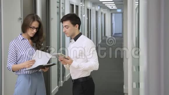 年轻的同事站在公司的走廊里说话视频的预览图