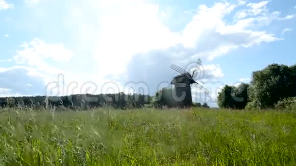 一块绿色的土地上的老磨坊视频的预览图