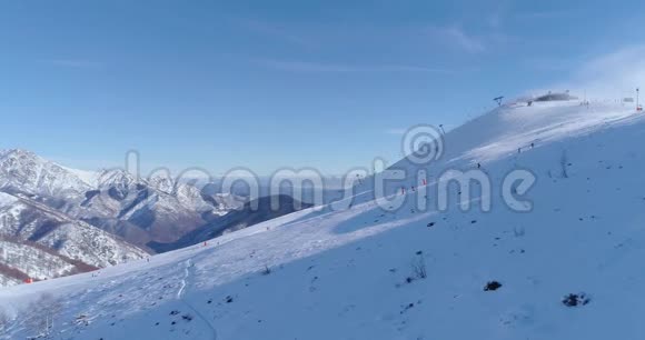 在阳光明媚的日子里人们在冬季雪山滑雪跑道上跟随滑雪者高山滑雪意大利阿尔卑斯山视频的预览图