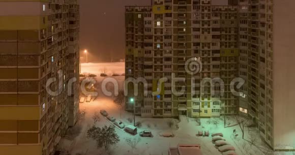 城市里的暴风雪晚上从窗口到庭院的景色向上向下视频的预览图