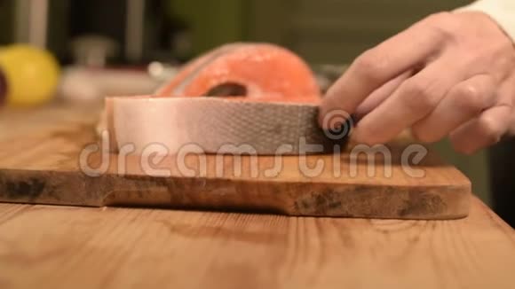 将三文鱼片切成薄片放在木切割板上家庭厨房健康食品视频的预览图