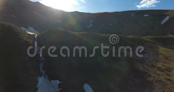 人们在喀尔巴阡山脉一条山涧附近的一片绿色空地上休息空中拍摄视频的预览图