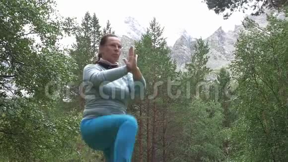 一个女人在山上做运动她从事冥想和瑜伽健康的生活方式慢动作视频的预览图