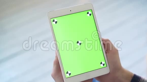 使用平板电脑与绿色屏幕一个男人拿着一个带有绿色屏幕的智能平板电脑视频的预览图