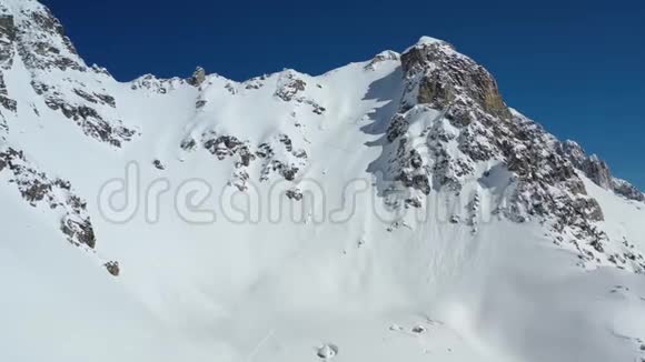 美丽的空中景色在一座覆盖着粉末雪的大山上一个人爬上它4K视频的预览图