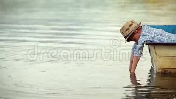 孤独的小男孩躺在船上望着水视频的预览图