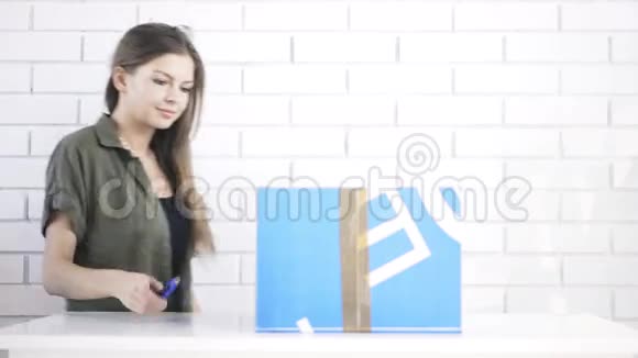 年轻女子用固定的刀打开盒子视频的预览图