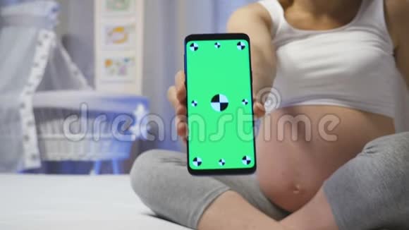 孕妇和带绿色屏幕的智能手机视频的预览图