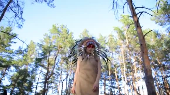 美洲印第安人看着美丽的女人在森林里散步视频的预览图