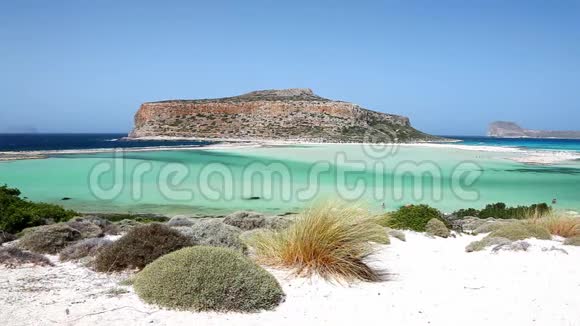 风在希腊克里特岛的巴洛斯海滩泻湖的白沙上移动草原在格莱弗斯岛上可以看到视频的预览图