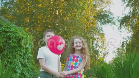 可爱的朋友夫妇与心脏气球在夏季公园视频的预览图