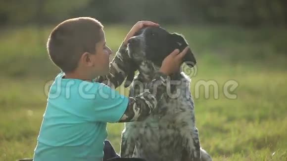男孩和狗坐在公园里视频的预览图