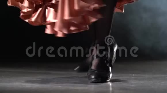 女孩的腿在跳踢踏舞从后面的光烟雾背景关门视频的预览图